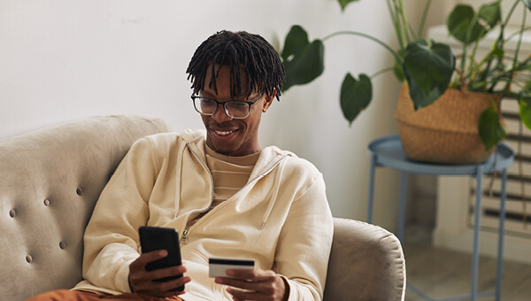 Young man paying online with People's choice visa debit card